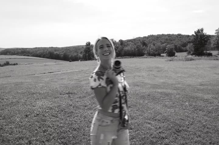 Victoria with her camera in a field